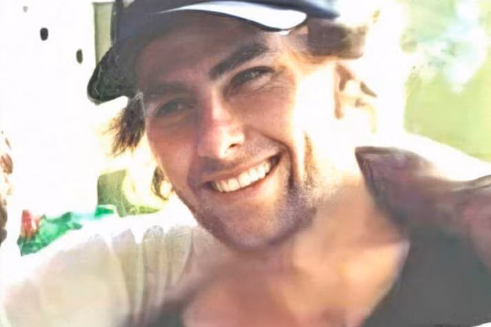 A smiling man wearing a cap.