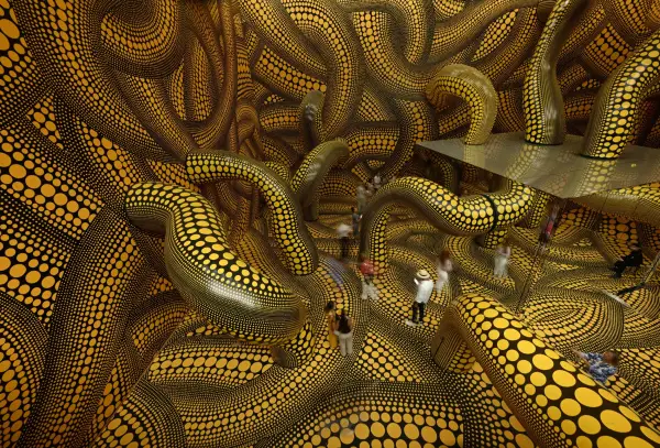 TOPSHOT - Visitors walk through the installation "Infinity Mirrored Room The Hope of the Polka Dots Buried in Infinity Will Eternally Cover the Universe" during the last day of the exhibition "Yayoi Kusama" by Japanese artist Yayoi Kusama at the Museum Ludwig in Cologne, western Germany, on August 2, 2026. For the Museum Ludwig in Cologne, the Kusama exhibition, that run from March 14 to August 2, 2026, has broken a record with over 470,000 visitors. The Museum Ludwig had organized this major exhibition of the Japanese artist Yayoi Kusama on the occasion of its 50th anniversary. The exhibition took visitors on a journey through Kusama's entire oeuvre with over 300 works, from her first drawings from around 1934 to the present day. Yayoi Kusama was born on March 22, 1929 and is now aged 97. (Photo by Ina FASSBENDER / AFP via Getty Images) / RESTRICTED TO EDITORIAL USE - MANDATORY MENTION OF THE ARTIST UPON PUBLICATION - TO ILLUSTRATE THE EVENT AS SPECIFIED IN THE CAPTION