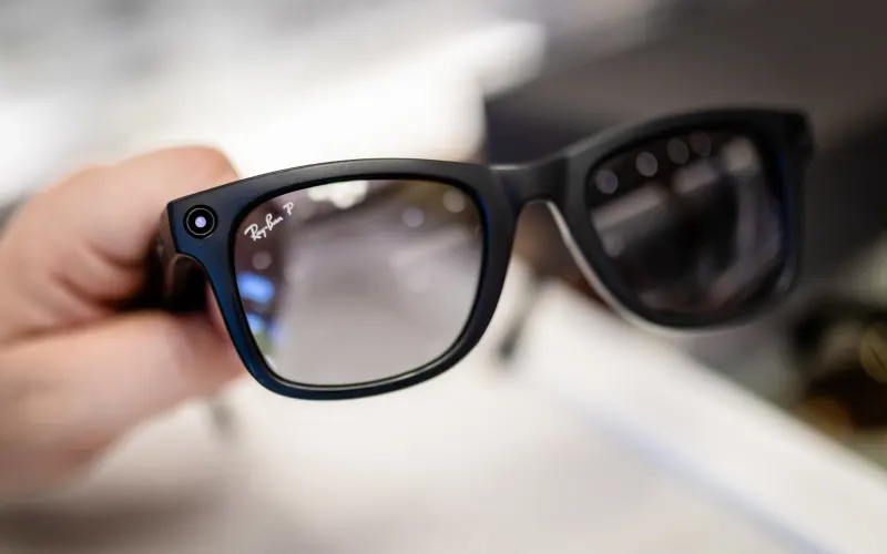 Жінка тримає в руці смарт-окуляри Ray-Ban Meta в магазині оптики. Оскільки ці окуляри дозволяють користувачам робити фото та відео, деякі басейни на відкритому повітрі та в приміщенні розглядають можливість їх заборони. Фото: Christoph Schmidt/dpa (Фото Christoph Schmidt / dpa Picture-Alliance через AFP)