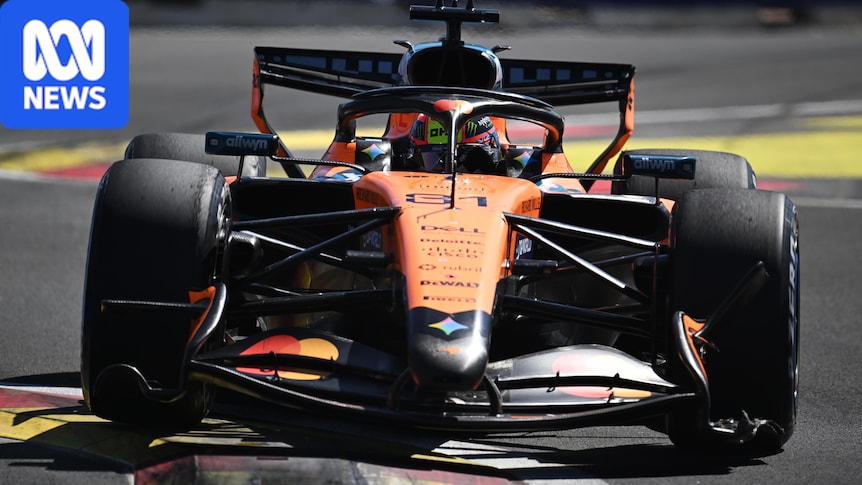 F1 car driving over a chicane on a track