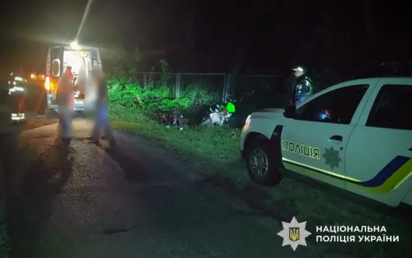 поліцейське авто на узбіччі, люди біля карети "швидкої"