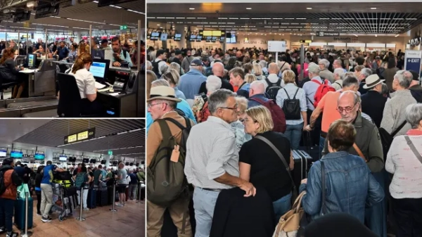 People stand in a line to check in after a cyber attack caused delays at Brussels International Airport in Zaventem, Belgium, Saturday, Sept. 20, 2025. (AP Photo/Harry Nakos)